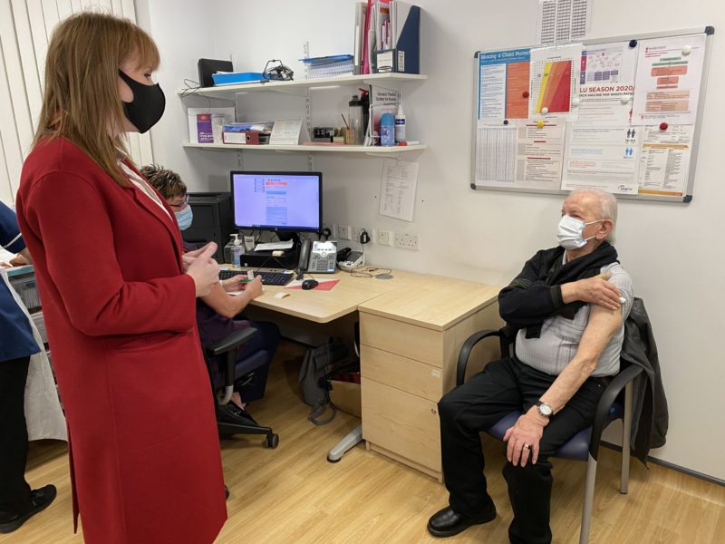 Angela watches Alan have his Pfizer vaccine